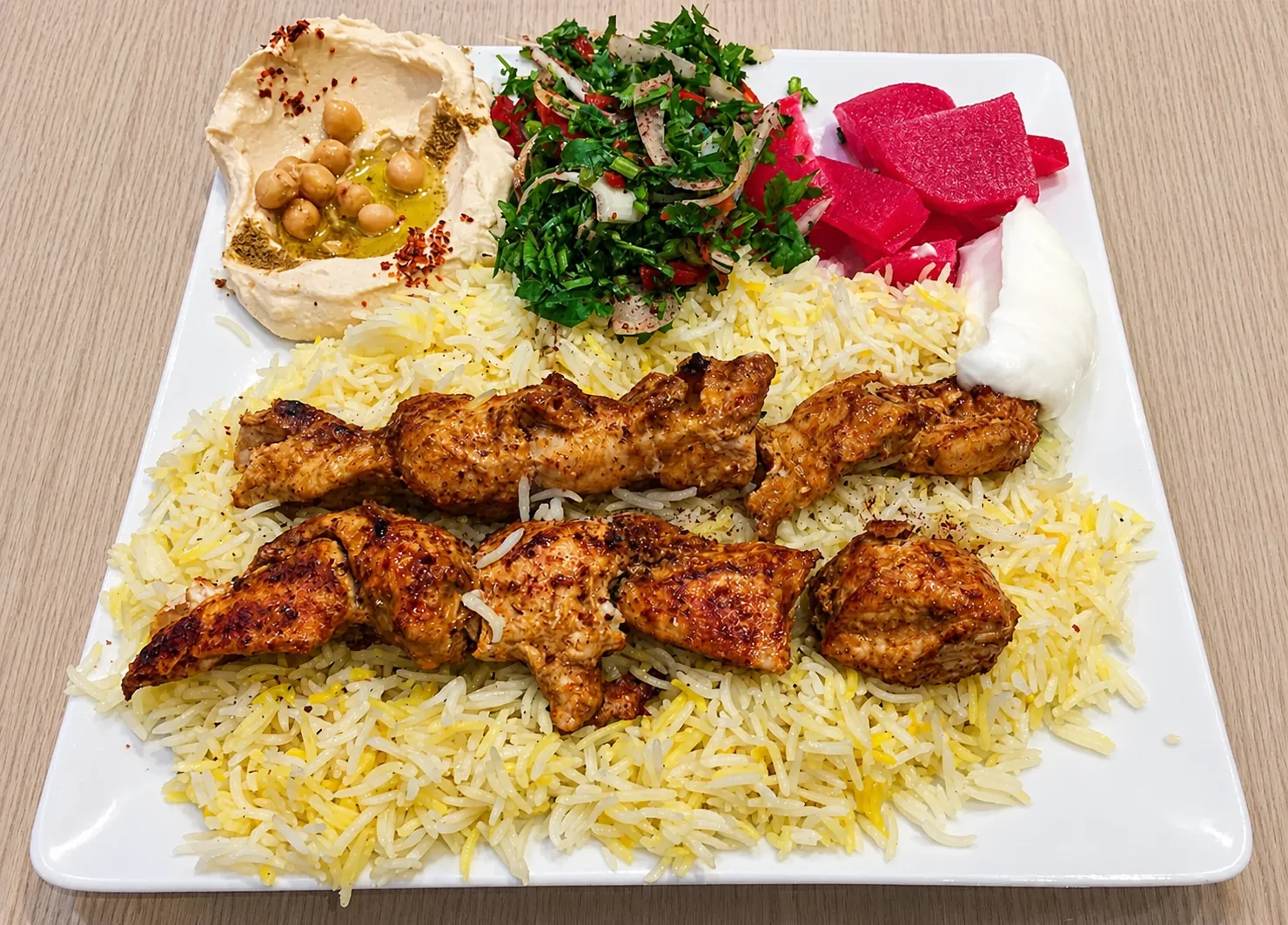 Orientalischer Grillteller mit Hähnchen, Reis, Hummus und Salat